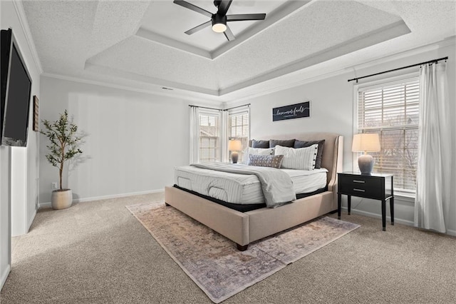 bedroom with baseboards, ornamental molding, a textured ceiling, a raised ceiling, and carpet flooring