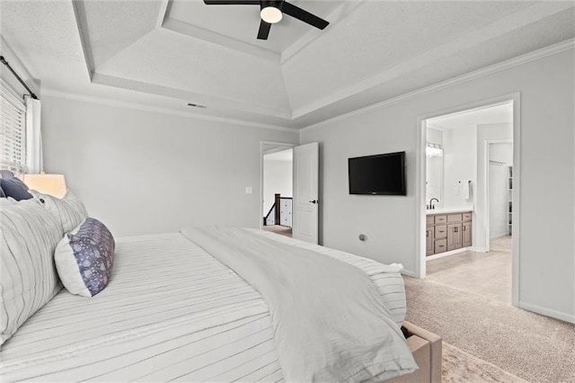 bedroom with a tray ceiling, baseboards, light colored carpet, and crown molding