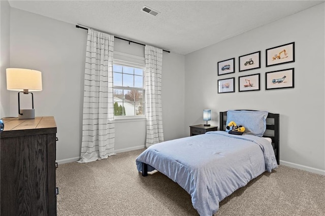 bedroom with a textured ceiling, baseboards, and carpet floors