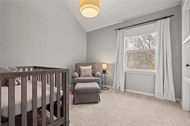 bedroom with a nursery area, baseboards, carpet, and vaulted ceiling