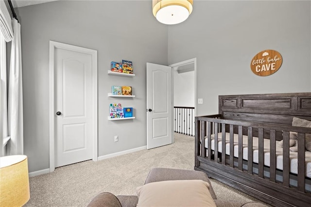 bedroom with a crib, baseboards, and carpet floors