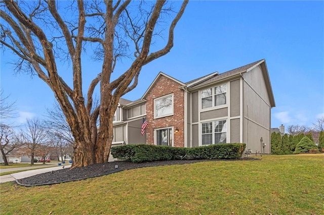 traditional home with brick siding and a front lawn