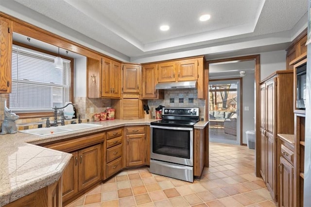 kitchen with a tray ceiling, ventilation hood, electric stove, and a sink