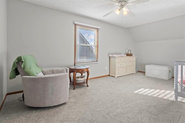 living area with light colored carpet, lofted ceiling, a textured ceiling, and baseboards