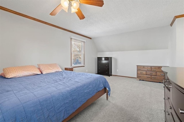 carpeted bedroom featuring a ceiling fan, baseboards, lofted ceiling, ornamental molding, and a textured ceiling