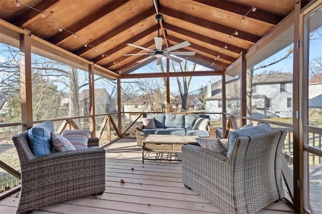 sunroom / solarium featuring lofted ceiling, a healthy amount of sunlight, and a ceiling fan