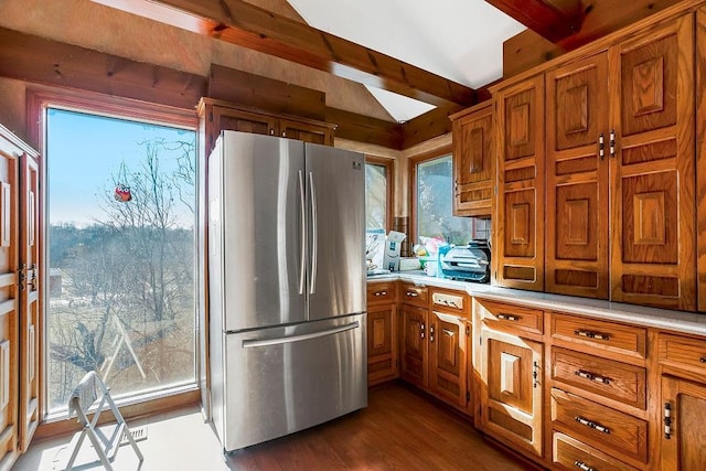 kitchen with brown cabinets, wood finished floors, light countertops, and freestanding refrigerator