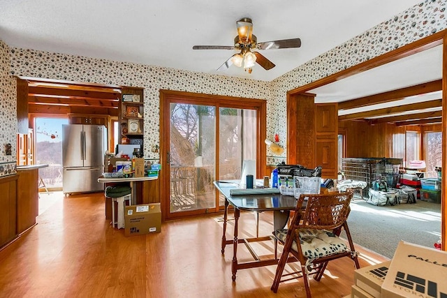 dining room featuring wallpapered walls, light wood-style floors, and a ceiling fan