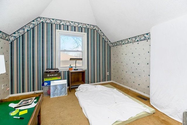 carpeted bedroom featuring wallpapered walls, vaulted ceiling, baseboards, and visible vents