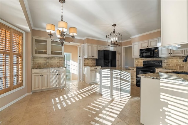 kitchen with light stone countertops, ornamental molding, decorative backsplash, black appliances, and a notable chandelier