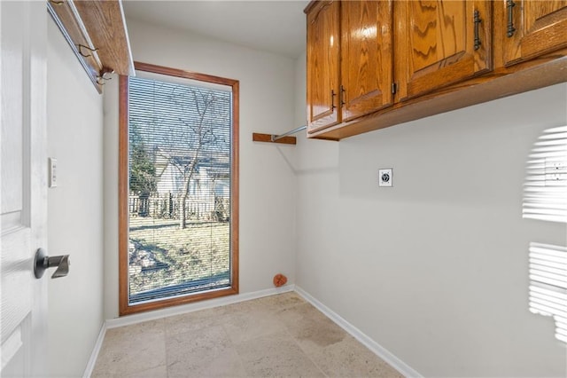 laundry room featuring cabinet space, baseboards, and hookup for an electric dryer