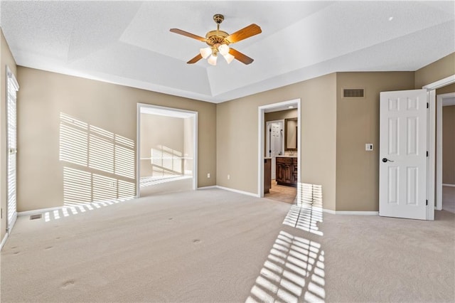 unfurnished room with visible vents, baseboards, light colored carpet, and ceiling fan