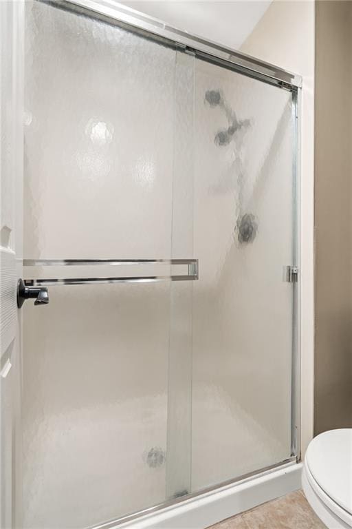 bathroom with a shower stall and toilet