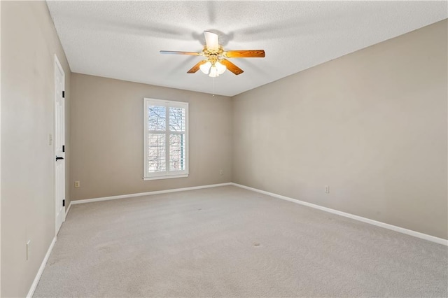 carpeted empty room featuring a ceiling fan, baseboards, and a textured ceiling