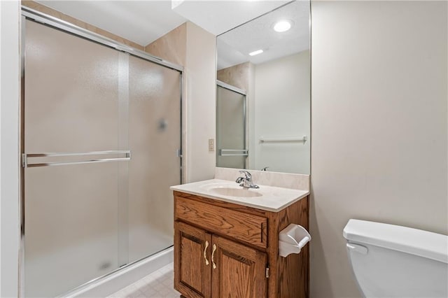 full bath featuring vanity, toilet, and a shower stall