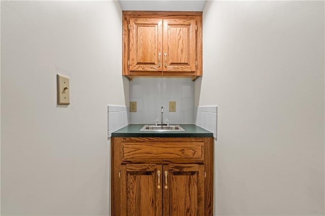 bar with a sink, decorative backsplash, and wet bar