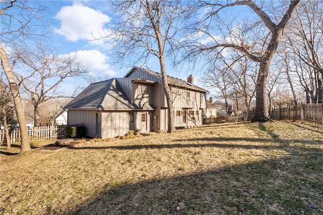 view of property exterior with a lawn, a chimney, and fence