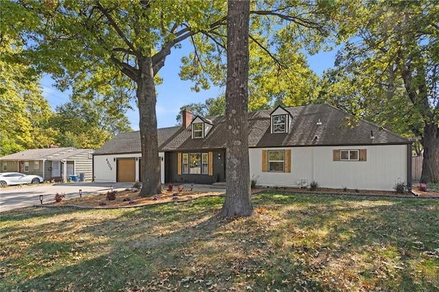 view of front of home featuring a garage, a front lawn, a chimney, and driveway