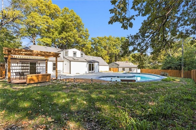 back of property featuring a fenced in pool, a pergola, a deck, fence private yard, and a lawn