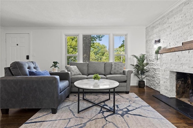 living room featuring a textured ceiling, wood finished floors, a fireplace, and ornamental molding