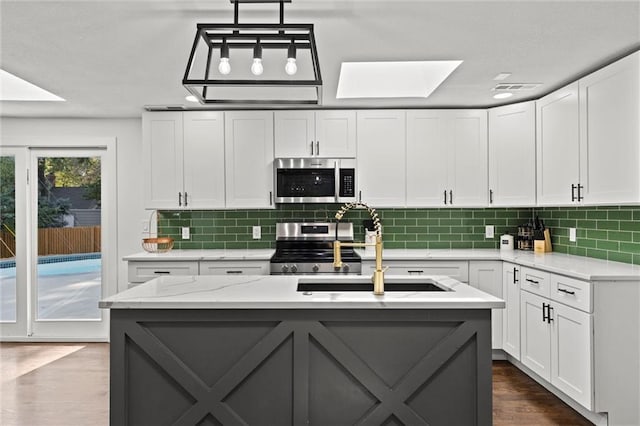 kitchen with dark wood-style floors, backsplash, white cabinets, and stainless steel appliances