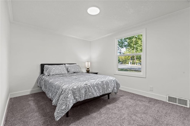 carpeted bedroom featuring crown molding, baseboards, visible vents, and a textured ceiling