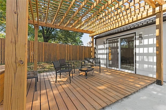 wooden terrace featuring fence, a pergola, and a fire pit