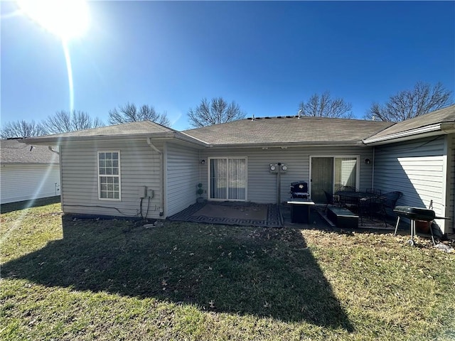 back of property featuring a patio area and a lawn