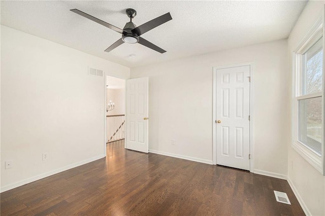 unfurnished bedroom featuring visible vents, baseboards, and wood finished floors
