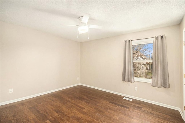 unfurnished room featuring visible vents, baseboards, a ceiling fan, and dark wood-style flooring