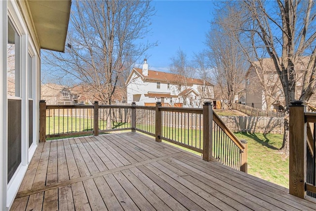 wooden terrace featuring a residential view, a lawn, and fence private yard