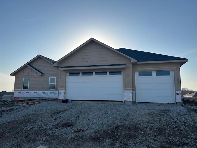 exterior space featuring an attached garage and gravel driveway