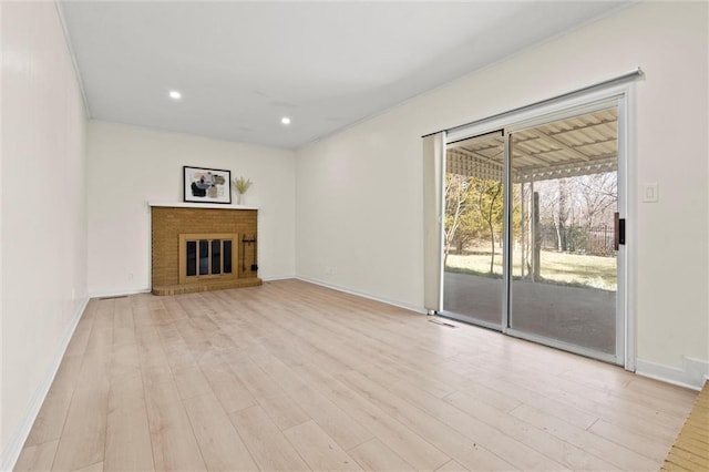 unfurnished living room with recessed lighting, a fireplace, light wood-style floors, and baseboards