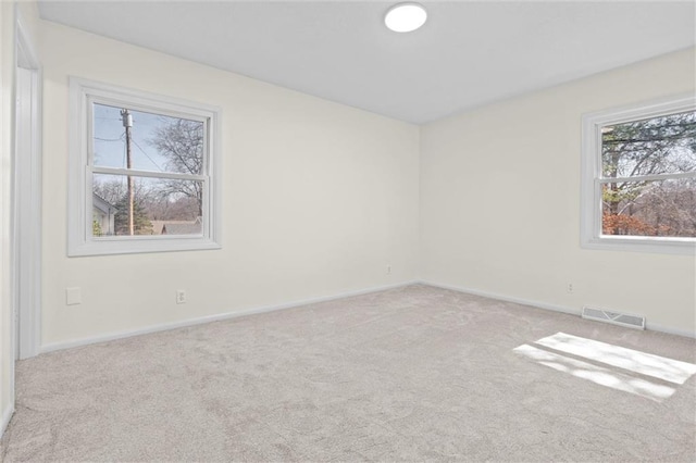 carpeted empty room with visible vents and baseboards