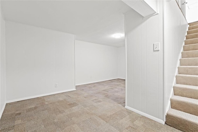 finished below grade area featuring carpet flooring, stairs, and baseboards