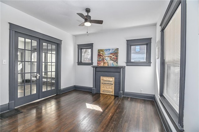 unfurnished living room with visible vents, hardwood / wood-style floors, a fireplace, and french doors