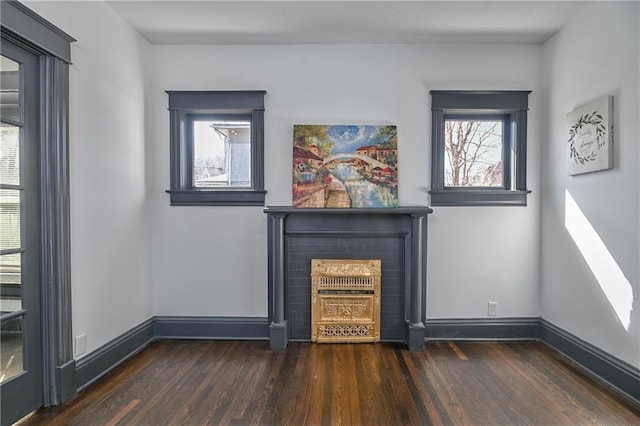 unfurnished living room featuring wood finished floors, a fireplace, and baseboards