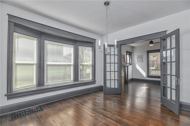 unfurnished dining area with visible vents, wood finished floors, baseboards, and french doors