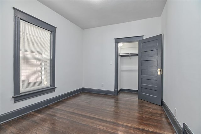 unfurnished bedroom with a closet, baseboards, and wood finished floors