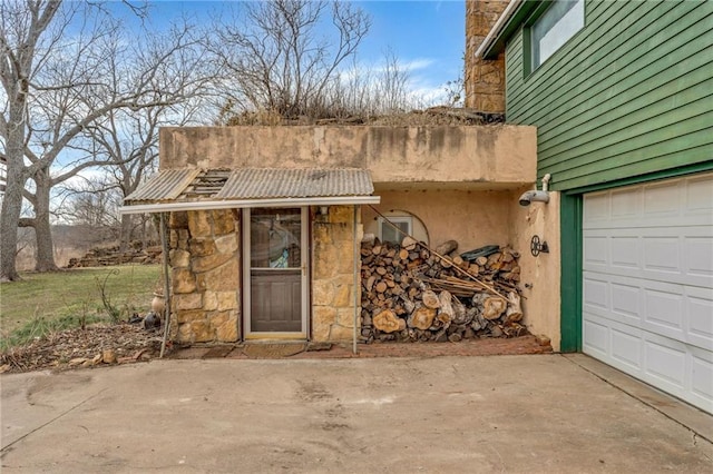 view of exterior entry featuring a garage and driveway