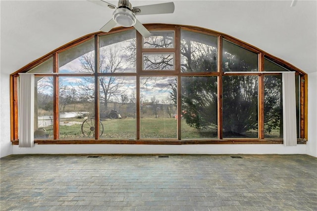 unfurnished sunroom with visible vents, lofted ceiling, and a ceiling fan