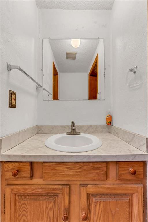 bathroom featuring a textured ceiling and vanity