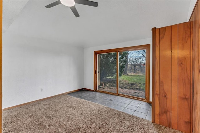 carpeted spare room featuring tile patterned flooring, ceiling fan, and baseboards