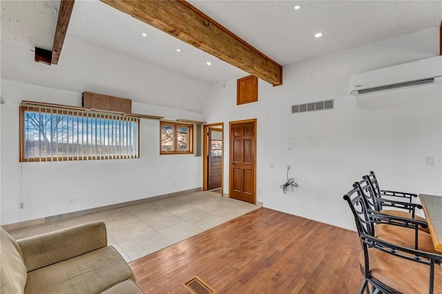 living area featuring visible vents, recessed lighting, a wall unit AC, and hardwood / wood-style flooring