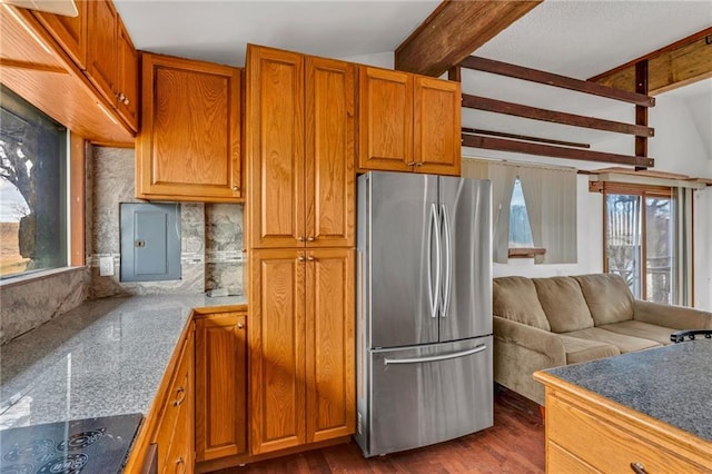 kitchen with black electric stovetop, electric panel, a healthy amount of sunlight, and freestanding refrigerator