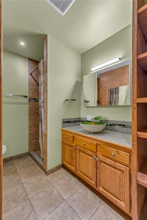 full bathroom with curtained shower, toilet, vanity, and tile patterned flooring