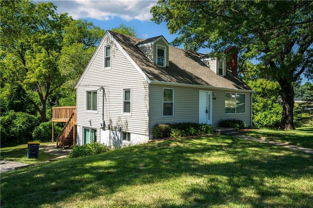 back of property with stairway, a lawn, roof with shingles, and a deck