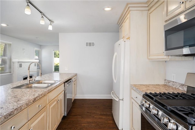 kitchen with visible vents, a sink, stainless steel appliances, light countertops, and cream cabinets