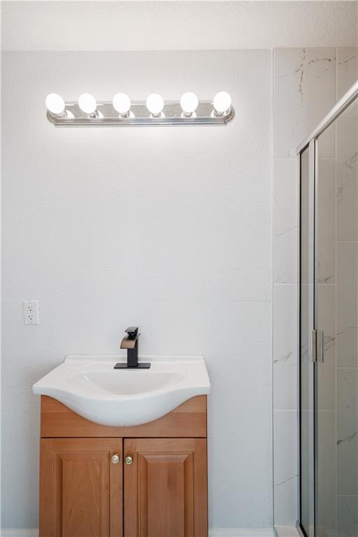 full bathroom with a shower stall and vanity