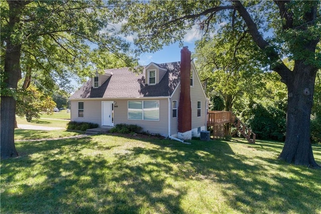 cape cod home featuring central air condition unit, a chimney, and a front lawn